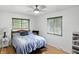 Bright bedroom with hardwood floors, a ceiling fan, and two windows offering natural light at 8219 Bishops Ln, Indianapolis, IN 46217