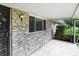Side of home with stone exterior, covered porch, and ornate metalwork on front door at 8219 Bishops Ln, Indianapolis, IN 46217