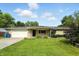 Charming stone ranch home with a well-manicured lawn, mature trees, and an attached one car garage at 8219 Bishops Ln, Indianapolis, IN 46217
