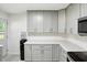 Bright updated kitchen features gray cabinets, stainless steel appliances, stone counters and great natural light at 8219 Bishops Ln, Indianapolis, IN 46217