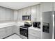 A bright kitchen features stainless appliances, gray cabinets, and lovely stone countertops at 8219 Bishops Ln, Indianapolis, IN 46217