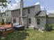Exterior view of the home's backyard featuring a wooden deck with hot tub and a well maintained lawn at 8415 Alcona Dr, Indianapolis, IN 46237