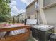 A view of the backyard wooden deck with hot tub and outdoor grill with a cloudy blue sky at 8415 Alcona Dr, Indianapolis, IN 46237