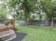 Landscaped backyard with a small wood deck area and well manicured lawn at 8415 Alcona Dr, Indianapolis, IN 46237