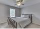 Neutral bedroom featuring metal bed frame, ceiling fan, and window at 8415 Alcona Dr, Indianapolis, IN 46237