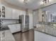 Well-lit kitchen features stainless appliances, granite counters, and white cabinets at 8415 Alcona Dr, Indianapolis, IN 46237