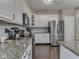 Well-lit kitchen featuring granite countertops, stainless steel appliances, and white cabinetry at 8415 Alcona Dr, Indianapolis, IN 46237