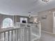 Carpeted landing features a window, chandelier, and view of the living room at 8415 Alcona Dr, Indianapolis, IN 46237