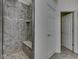 Tiled shower with a built-in seat, designer tile, and glass door at 8415 Alcona Dr, Indianapolis, IN 46237
