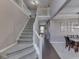 Inviting foyer featuring a carpeted staircase and hardwood floors leading to a welcoming dining area at 8415 Alcona Dr, Indianapolis, IN 46237