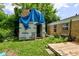 Backyard view of unfinished shed with building supplies under a blue tarp next to a brick home at 8540 E 37Th Pl, Indianapolis, IN 46226