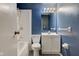 Blue bathroom showcases a tub, toilet, vanity and modern fixtures at 8540 E 37Th Pl, Indianapolis, IN 46226