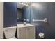 Clean blue bathroom offers a toilet, vanity with storage and modern lighting at 8540 E 37Th Pl, Indianapolis, IN 46226