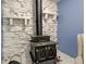 Close-up of a vintage wood-burning stove surrounded by a white stone fireplace at 8540 E 37Th Pl, Indianapolis, IN 46226