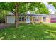 Charming brick home with a well-maintained lawn and mature tree providing shade at 8540 E 37Th Pl, Indianapolis, IN 46226