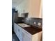 Modern kitchen features white cabinets, dark countertops, stainless steel appliances, and decorative backsplash at 8540 E 37Th Pl, Indianapolis, IN 46226