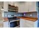 Bright kitchen featuring white cabinets, stainless steel appliances, and patterned backsplash at 8540 E 37Th Pl, Indianapolis, IN 46226