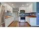 Modern kitchen showcasing white cabinets, a stainless steel oven and hardwood flooring at 8540 E 37Th Pl, Indianapolis, IN 46226