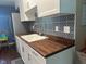 Renovated kitchen with stainless steel appliances, white cabinets, modern tile backsplash and new countertops at 8540 E 37Th Pl, Indianapolis, IN 46226