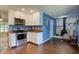 Well-lit kitchen adjacent to a living area with blue walls and white stone fireplace at 8540 E 37Th Pl, Indianapolis, IN 46226