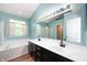 Bathroom with a double sink vanity, large mirror, soaking tub, and a window at 8578 Nolan Dr, Fishers, IN 46038