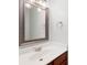 Elegant bathroom vanity, featuring a framed mirror, dark wood trim, and a modern chrome faucet and countertop at 8578 Nolan Dr, Fishers, IN 46038
