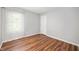 This bedroom has modern laminate flooring, freshly painted neutral walls, and one window with white curtains at 8578 Nolan Dr, Fishers, IN 46038