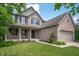 Attractive two-story home showcasing a welcoming front porch and a beautiful lawn with mature trees at 8578 Nolan Dr, Fishers, IN 46038