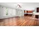 Bright living room featuring hardwood floors and large windows, offering views into the well-equipped kitchen at 8578 Nolan Dr, Fishers, IN 46038