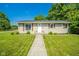 Charming single story home has a manicured lawn, sidewalk and mature trees at 901 N Greenbriar Rd, Muncie, IN 47304