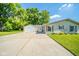 Inviting home showcasing a large driveway, attached two-car garage, and manicured lawn at 901 N Greenbriar Rd, Muncie, IN 47304