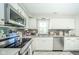 Kitchen featuring white cabinets, stainless steel appliances, and dark tile backsplash at 901 N Greenbriar Rd, Muncie, IN 47304