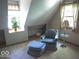 Attic space featuring a comfortable chair and ottoman set next to two windows at 908 Queensbury Dr, Noblesville, IN 46062