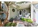 Cozy front porch with a brick walkway, decorated with a wreath, rocking chair, and potted plants at 908 Queensbury Dr, Noblesville, IN 46062