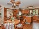 The kitchen and dining area feature light wood cabinets, an island cooktop, and wood flooring at 908 Queensbury Dr, Noblesville, IN 46062