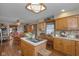 The kitchen features an island with cooktop and sink, light wood cabinetry, and a breakfast nook at 908 Queensbury Dr, Noblesville, IN 46062