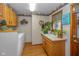 Bright laundry room with sink, cabinets and floral wallpaper border at 908 Queensbury Dr, Noblesville, IN 46062