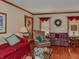 Living room features hardwood floors, colorful couches, and large windows with natural light at 908 Queensbury Dr, Noblesville, IN 46062