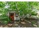Garden shed with red trim and a small window surrounded by foliage at 908 Queensbury Dr, Noblesville, IN 46062