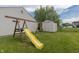 Backyard with wooden swing set, yellow slide, grassy yard, and shed. A great play area for ! at 939 Arabian Way, Bargersville, IN 46106