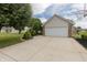 A spacious two-car garage with a basketball hoop and a wide driveway, complemented by lush landscaping at 939 Arabian Way, Bargersville, IN 46106