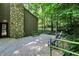 Wide, wooden deck with stone pillar, views of the surrounding trees, and chairs and a bench for outdoor living at 944 Briar Patch Ln, Greenwood, IN 46142