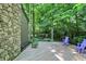 Wide, wooden deck with stone pillar and views of the surrounding trees, equipped with chairs for outdoor living at 944 Briar Patch Ln, Greenwood, IN 46142