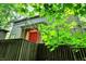 Exterior view of house with green exterior, red double-door entrance, and vibrant surrounding foliage at 944 Briar Patch Ln, Greenwood, IN 46142