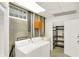 Basement laundry with washer, dryer, utility sink, shelving, and concrete walls at 944 Briar Patch Ln, Greenwood, IN 46142