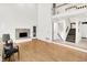 Bright living room with modern fireplace, hardwood floors, and staircase leading to an upper level at 944 Briar Patch Ln, Greenwood, IN 46142