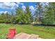 Secluded backyard with lush greenery, trees, and a cozy deck featuring a comfortable red chair at 951 Curlew Ln, Greenwood, IN 46143