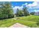 Lush backyard features green grass, mature trees offering shade and privacy, and a glimpse of a wooden deck at 951 Curlew Ln, Greenwood, IN 46143