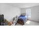 Bright bedroom featuring a wooden bed frame, white walls, and a nearby gaming desk setup at 951 Curlew Ln, Greenwood, IN 46143