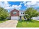 Charming two-story home with brick accents, a front yard, and attached garage at 951 Curlew Ln, Greenwood, IN 46143
